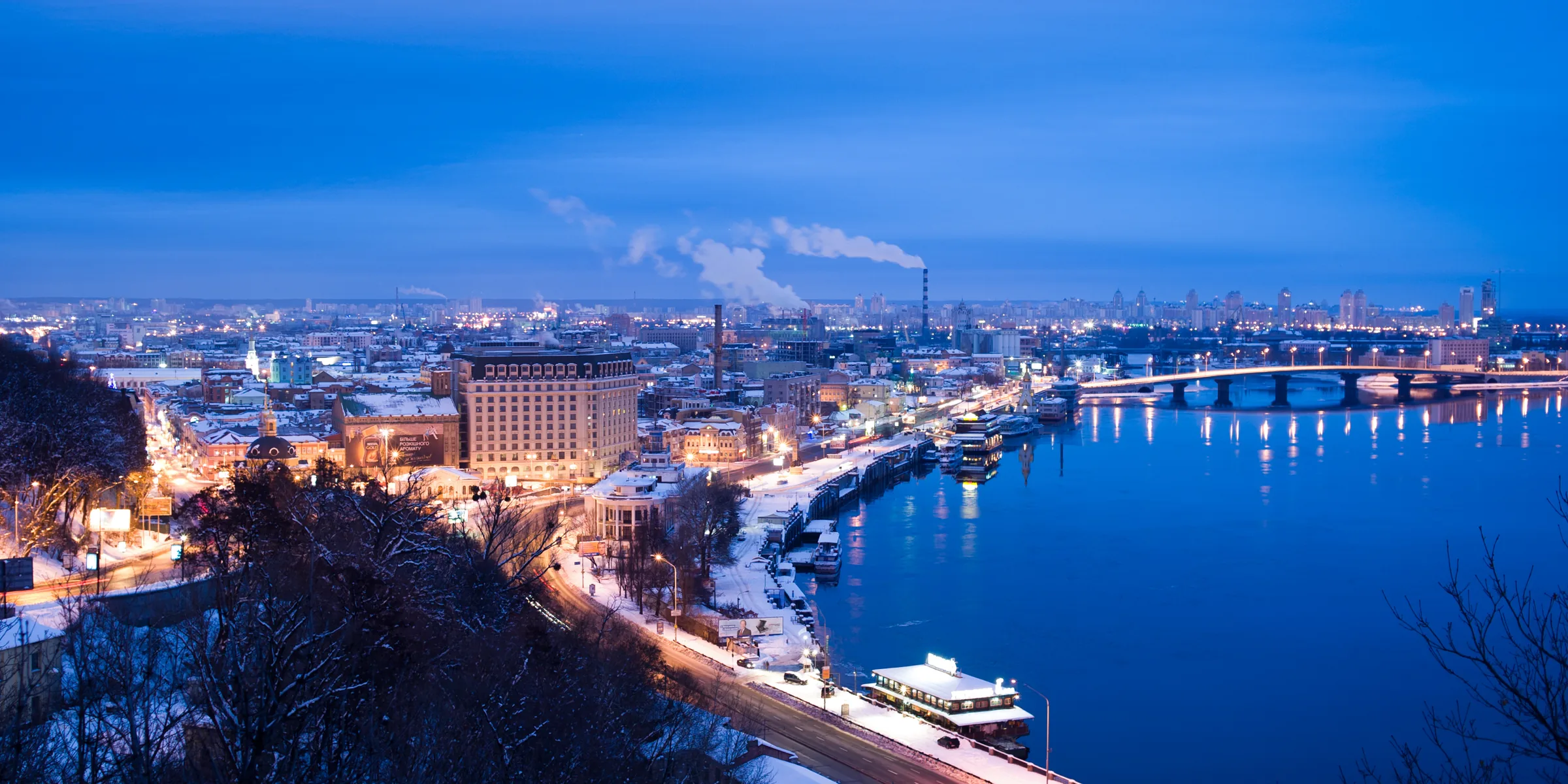 An evening panorama of Podil and the Dnipro embankment in Kyiv